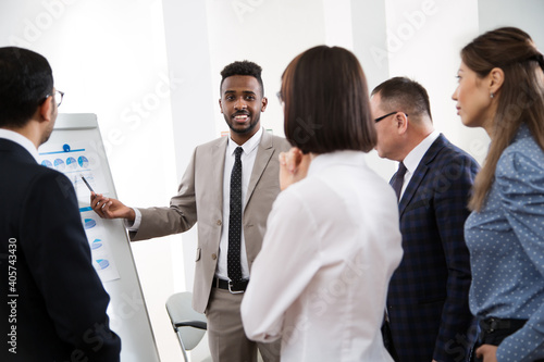 Group of multy-ethnic business people having a meeting using a white board in an office