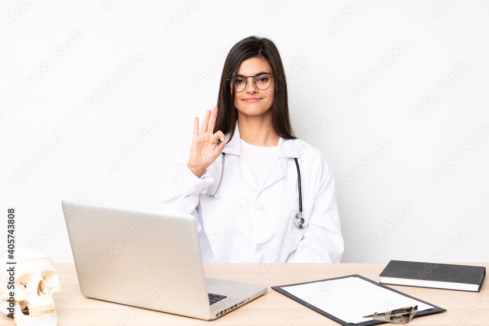 Professional traumatologist in workplace showing an ok sign with fingers Professional traumatologist in workplace showing an ok sign with fingers