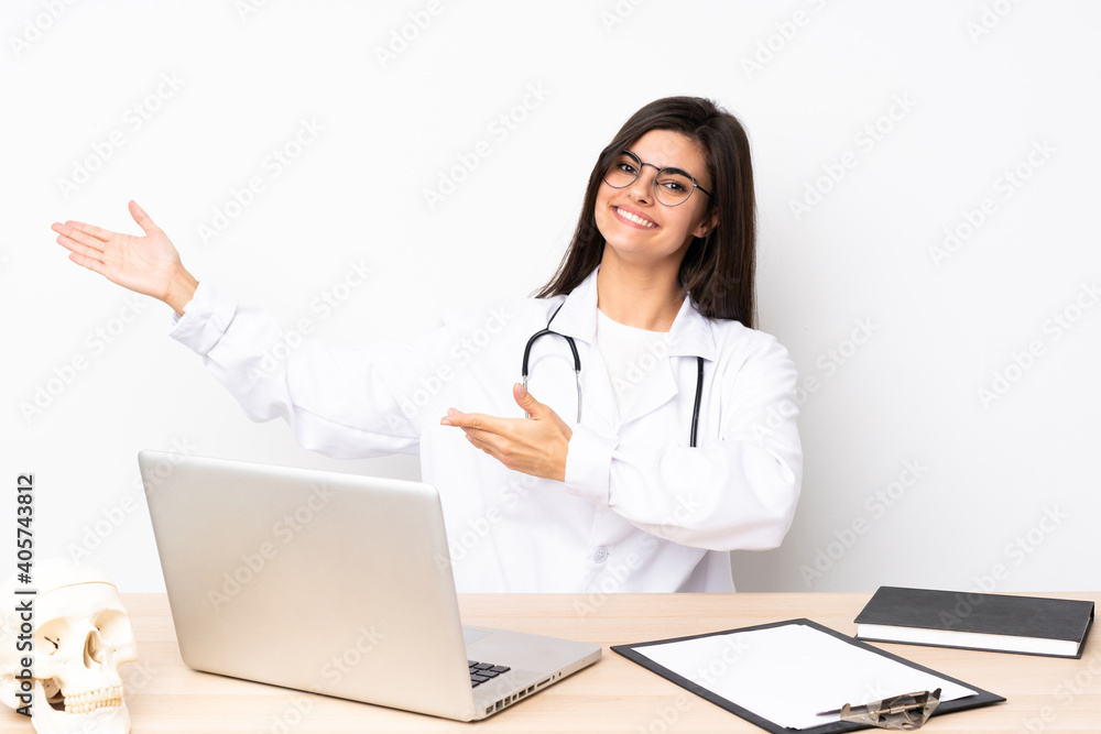 Professional traumatologist in workplace extending hands to the side for inviting to come Professional traumatologist in workplace extending hands to the side for inviting to come