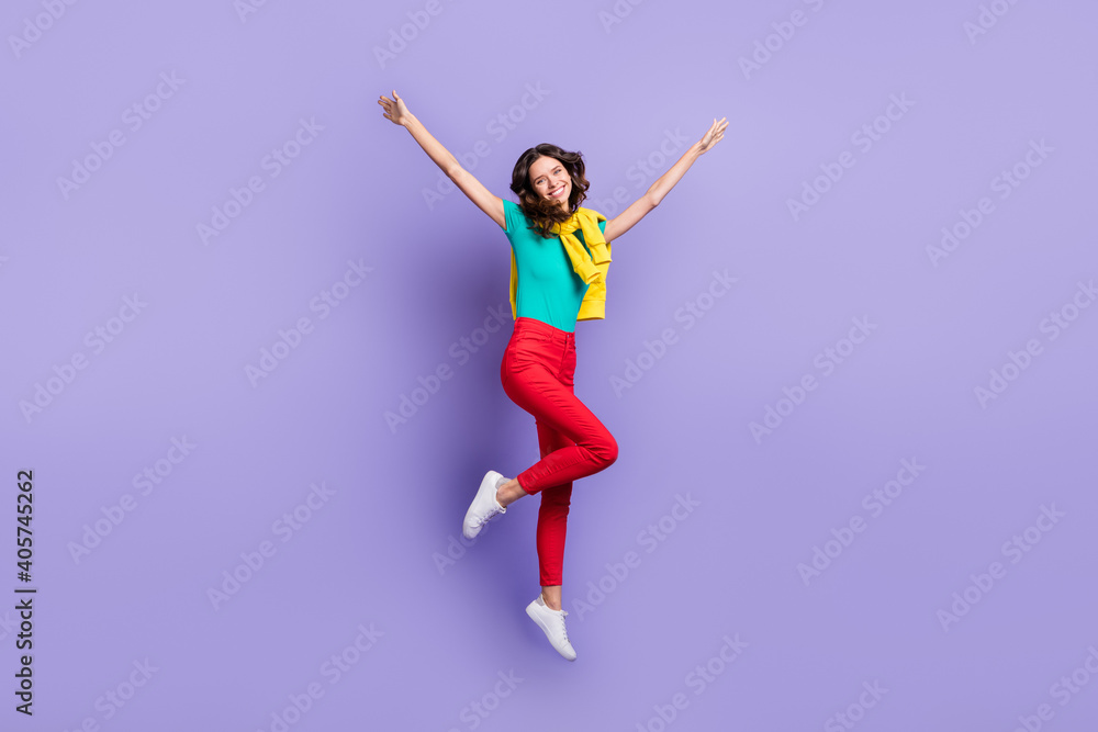 Full length photo of charming shiny wavy woman dressed pullover shoulders jumping rising hands isolated purple color background
