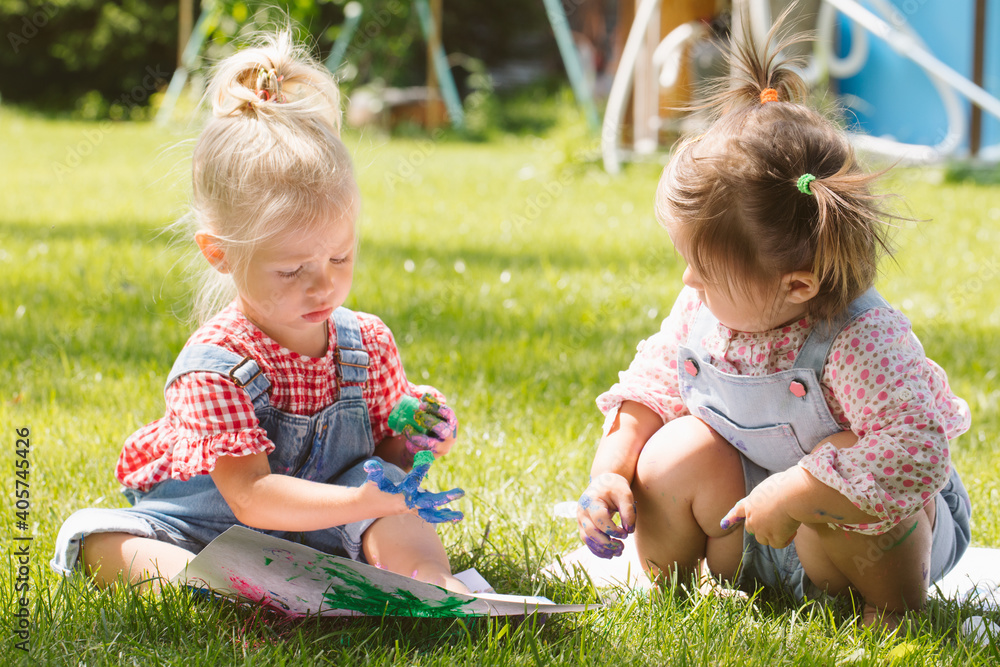 Two little girls sisters paint with finger paints Two little girls sisters paint with finger paints
