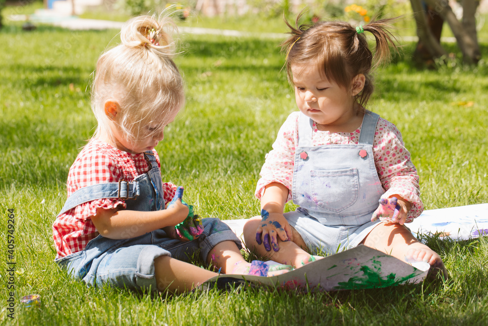 Two little girls sisters paint with finger paints Two little girls sisters paint with finger paints