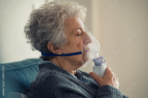 Photographie Sick senior woman making inhalation with nebulizer