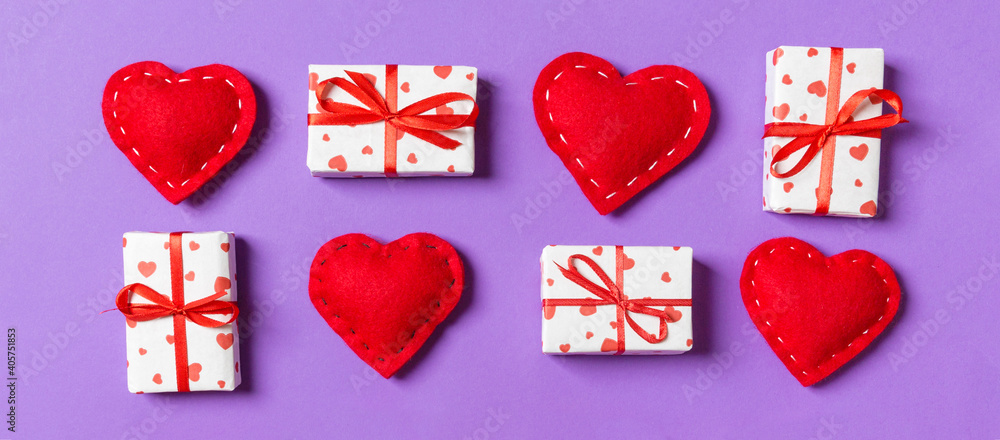 Top view of white gift boxes and red textile hearts on colorful background. Valentine's Day concept