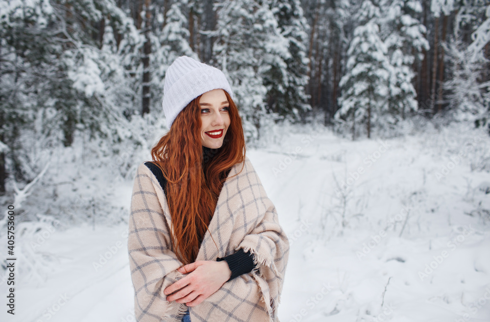 A young girl with long bright red hair on a winter background.A red-haired woman in a white cap. A young girl with long bright red hair on a winter background.A red-haired woman in a white cap.