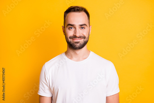 Portrait of attractive content cheerful bearded guy freelancer isolated over bright yellow color background