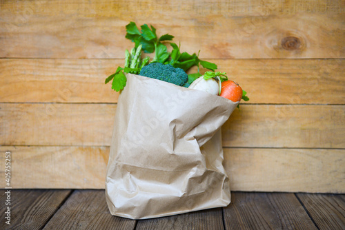 Fresh vegetable from market take away paper bag shopping on wooden table, Delivery healthy food in paper bag grocery shopping concept.