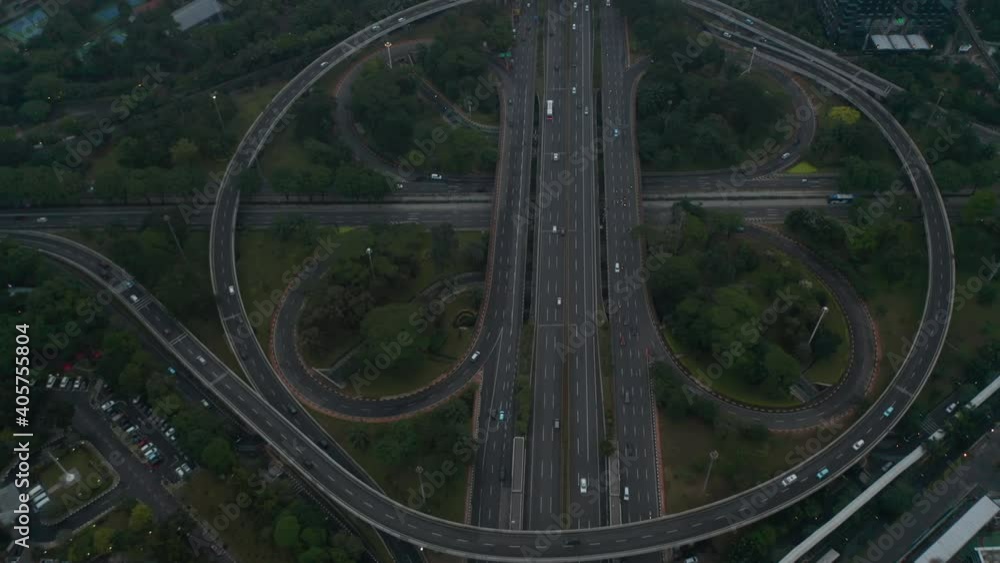 Aerial dolly tilt shot flying over busy multi lane intersection full of vehicles in modern city center Aerial dolly tilt shot flying over busy multi lane intersection full of vehicles in modern city center