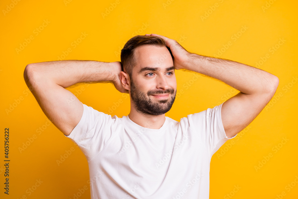 Portrait of attractive groomed content guy caressing soft smooth hair isolated over bright yellow color background Portrait of attractive groomed content guy caressing soft smooth hair isolated over bright yellow color background