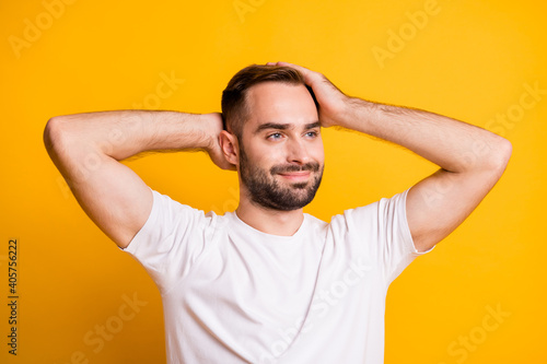 Portrait of attractive groomed content guy caressing soft smooth hair isolated over bright yellow color background © deagreez