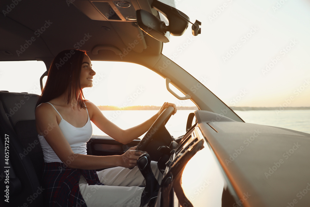 Young woman in car on road trip - obrazy, fototapety, plakaty 