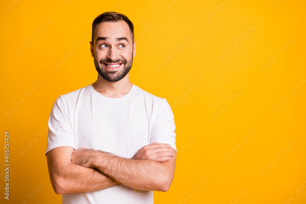 Portrait of attractive cheerful bearded curious guy folded arms copy space thinking isolated over bright yellow color background Portrait of attractive cheerful bearded curious guy folded arms copy space thinking isolated over bright yellow color background