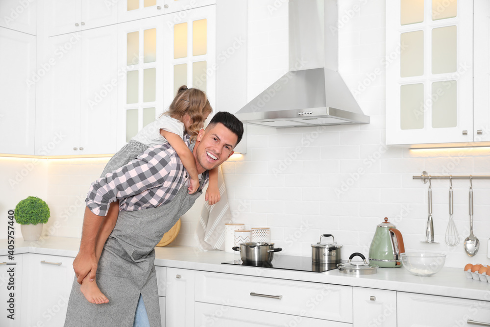 Little girl with her father cooking together in modern kitchen Little girl with her father cooking together in modern kitchen