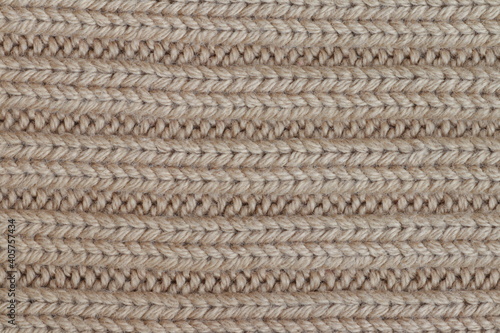 Texture of beige knitted sweater fabric.
