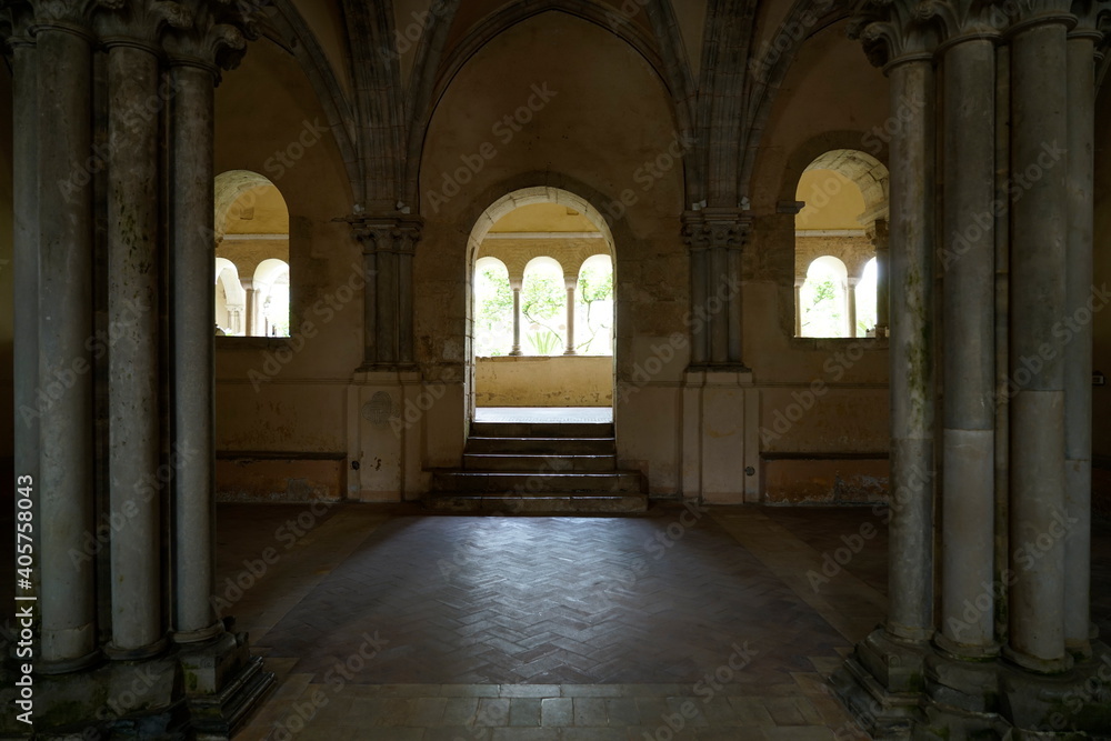 archi illuminati in controluce chiari e con archi scuri che incorniciano quelli scuri , abbazia medioevale