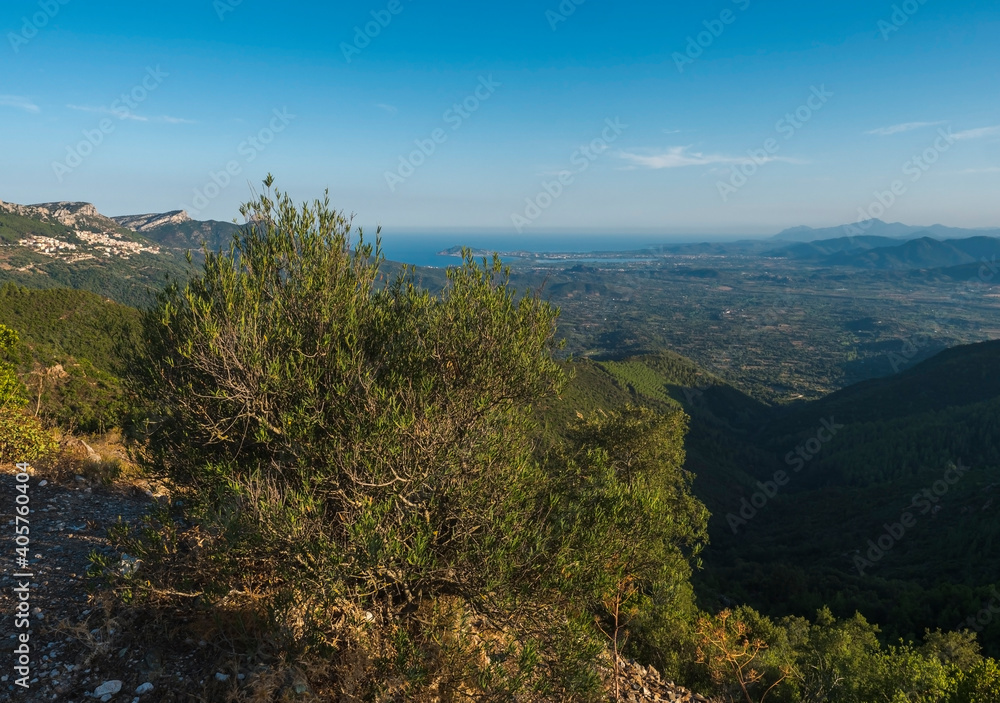 Aerial View of green landscape of Supramonte Mountains with Baunei and Arbatax village, limestone rocks and mediterranean sea and lush vegetation. Ogliastra, Sardinia, Italy. Summer blue sky Aerial View of green landscape of Supramonte Mountains with Baunei and Arbatax village, limestone rocks and mediterranean sea and lush vegetation. Ogliastra, Sardinia, Italy. Summer blue sky
