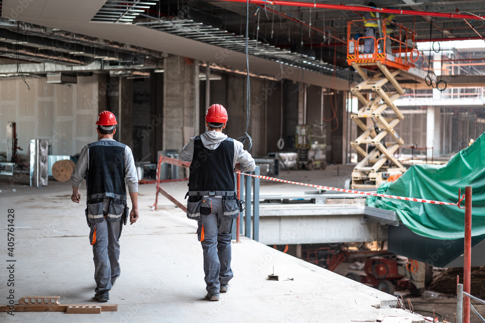 Two men on a construction site walking to work Two men on a construction site walking to work