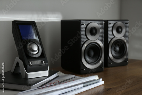 Modern powerful audio speakers and remote on table indoors