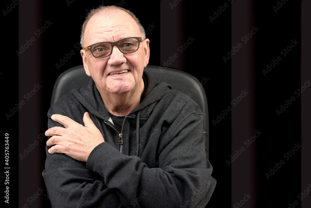 portrait vieil homme assis fauteuil sourire narquois sur fond noir