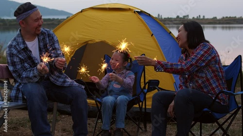 Asian family enjoy with firework sparkler at camping site.