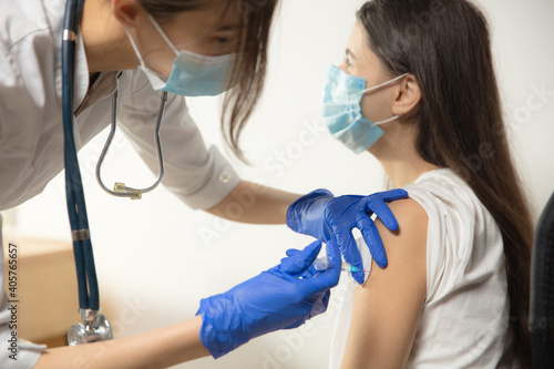 Protect. Close up doctor or nurse giving vaccine to patient using the syringe injected. Works in face mask. Protection against coronavirus  COVID-19 pandemic and pneumonia. Healthcare  medicine.