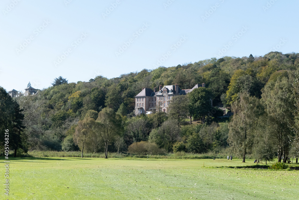 Large house behind trees next to golf course in Lake District Large house behind trees next to golf course in Lake District