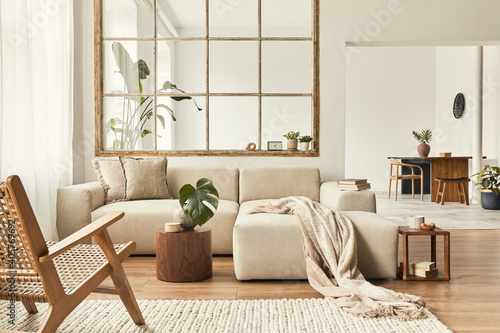 Fotografie Modern interior of open space with design modular sofa, furniture, wooden coffee tables, plaid, pillows, tropical plants and elegant personal accessories in stylish home decor