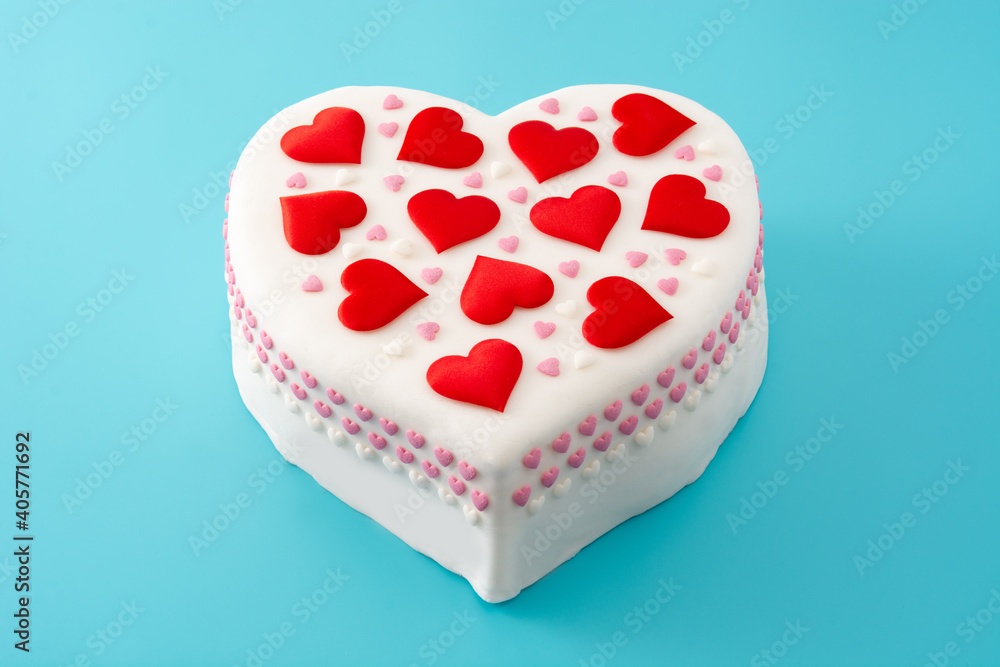 Heart cake for St. Valentine's Day, Mother's Day, or Birthday, decorated with sugar hearts on blue background	