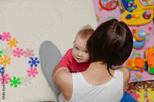 Mom plays with her daughter in toys. Mom hugs her little daughter.