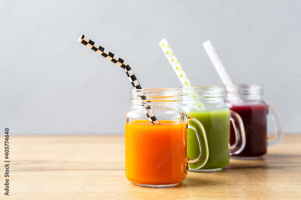 Nahaufnahme von Smoothies in Gläsern in einer Reihe. Holztisch, grauer isolierter Hintergrund. Gesundes Getränk. Nahaufnahme von Smoothies in Gläsern in einer Reihe. Holztisch, grauer isolierter Hintergrund. Gesundes Getränk.