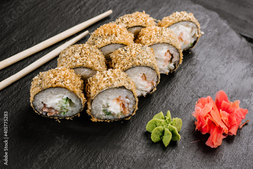 Hot tempura sushi rolls with cream cheese on black background