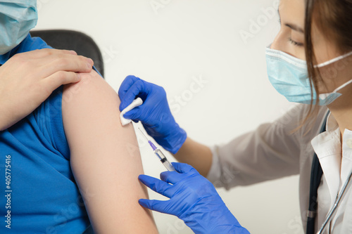 Healthy. Close up doctor or nurse giving vaccine to patient using the syringe injected. Works in face mask. Protection against coronavirus  COVID-19 pandemic and pneumonia. Healthcare  medicine.