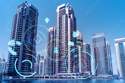 Skyscrapers of Dubai business downtown. International hub of trading and financial services. Technology theme icons hologram, Fintech concept. Double exposure. Dubai Canal waterfront.