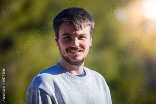 Young man smiling and looking at the camera in the middle of the field. Happiness and joy