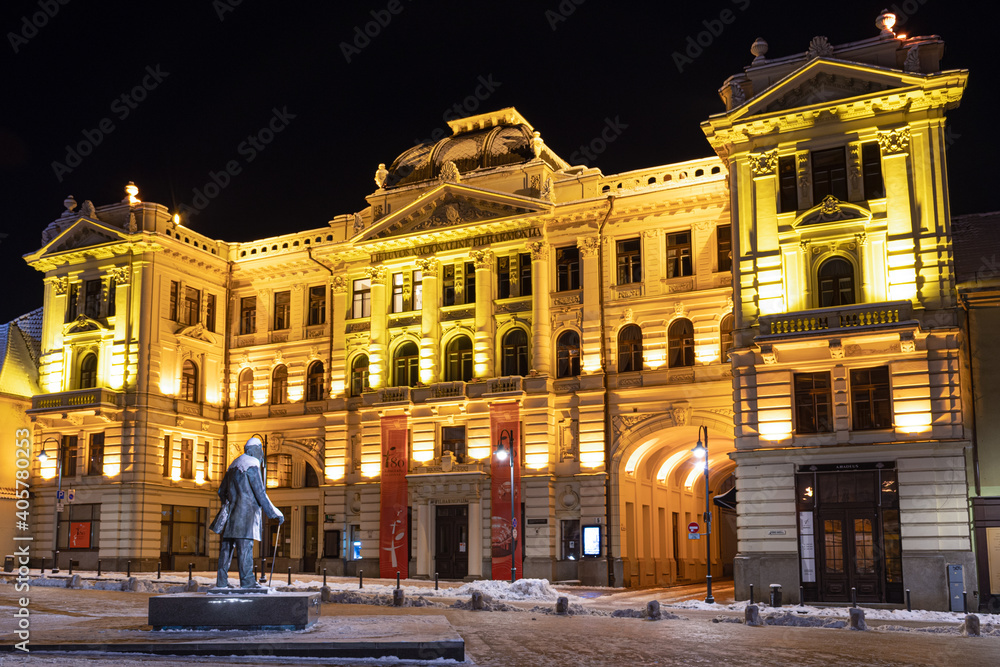 Lithuanian National Philharmonic in Vilnius, night view with snow and monument of Jonas Basanavičius