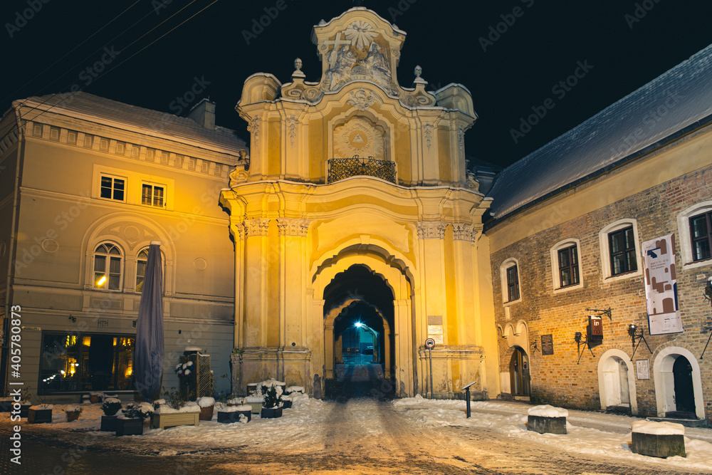 Holy Trinity Church and Basilian Gate, Basilian monastery gate in the Old Town in Vilnius in Lithuania, night view with snow  