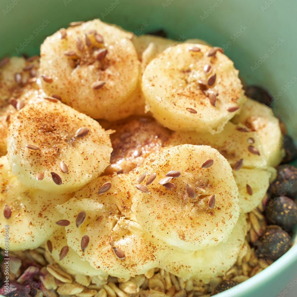 Healthy breakfast. Top view. Oatmeal with banana and flax seeds at bowl. Berry in plate. Organic meal recipe. Vegan cook. Minimalism granola. Hot porrigde with fruit. Closeup Healthy breakfast. Top view. Oatmeal with banana and flax seeds at bowl. Berry in plate. Organic meal recipe. Vegan cook. Minimalism granola. Hot porrigde with fruit. Closeup