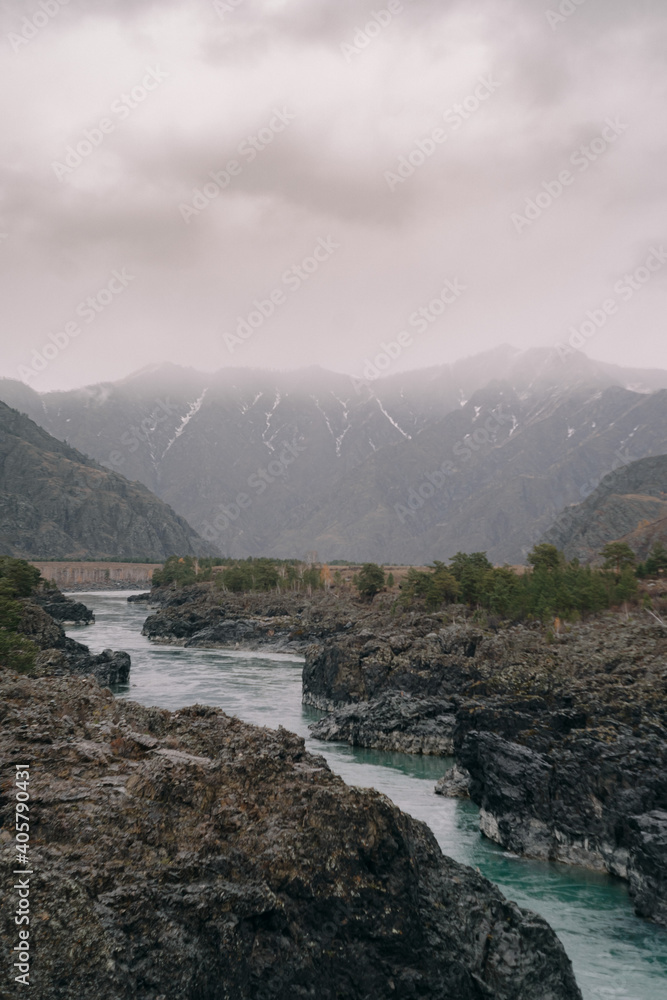 The blue river flows among the mountains in autumn in Altai