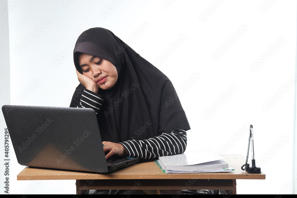 portrait of Asian woman wearing casual clothes working in an office. a hooded woman with a tired expression working at a computer. the concept of a difficult and unsatisfactory job portrait of Asian woman wearing casual clothes working in an office. a hooded woman with a tired expression working at a computer. the concept of a difficult and unsatisfactory job