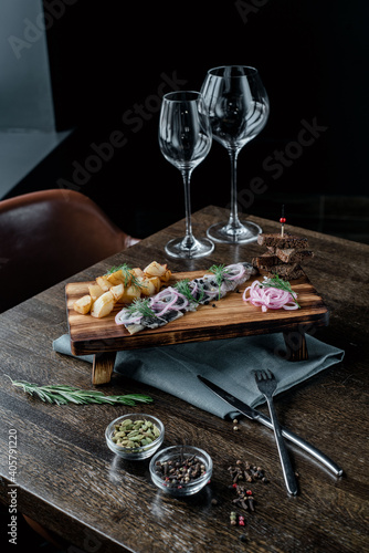 Board with snacks and glass glasses served on the table on a black background