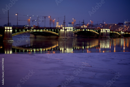 View of the Neva River, Birzhevoy Bridge and Petrogradsky Island on a winter evening in St. Petersburg, Russia. © Anna
