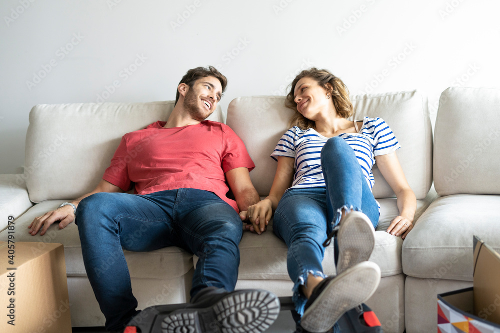 Young couple relaxing on sofa in their new house Young couple relaxing on sofa in their new house
