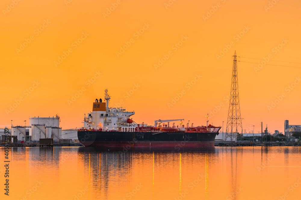 Fototapeta premium Commercial cargo ship at Port Adelaide docks viewed across Port River at sunset