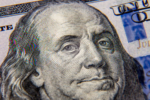 A close-up close-up shot of Benjamin Franklin's face on a $ 100 bill....