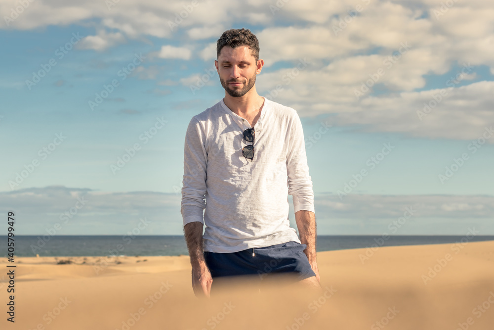 Young man walking in the dunes of Maspalomas in Gran Canaria Young man walking in the dunes of Maspalomas in Gran Canaria