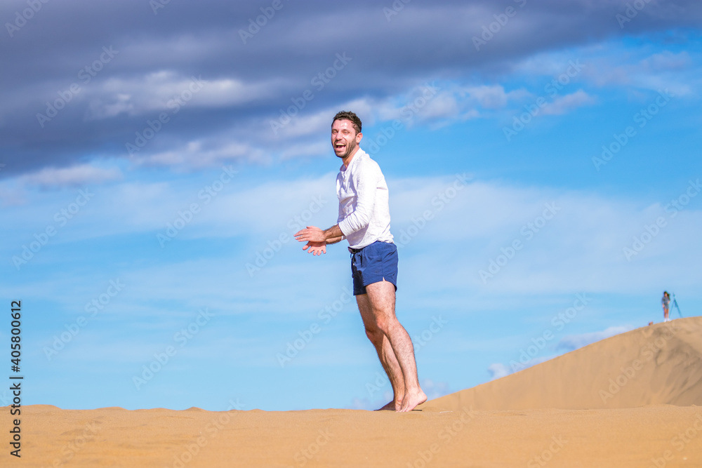 Young athletic man doing acrobatics in the sand of the dunes in Gran Canaria Young athletic man doing acrobatics in the sand of the dunes in Gran Canaria