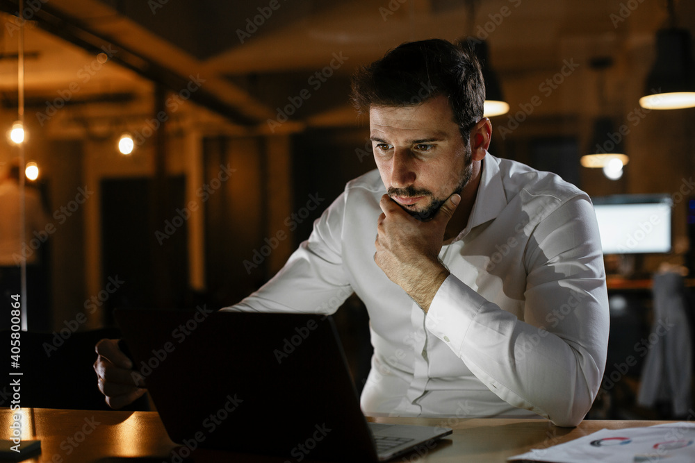 Young businessman working with laptop at office. Businessman sitting at office desk working on laptop computer