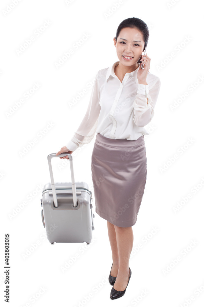 Businesswoman using cell phone and walking with suitcase Businesswoman using cell phone and walking with suitcase