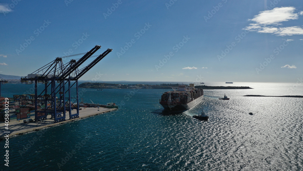 Aerial drone photo of container truck size cargo vessel approaching international container loading - unloading logistics terminal of Piraeus, Perama, Attica Greece Aerial drone photo of container truck size cargo vessel approaching international container loading - unloading logistics terminal of Piraeus, Perama, Attica Greece