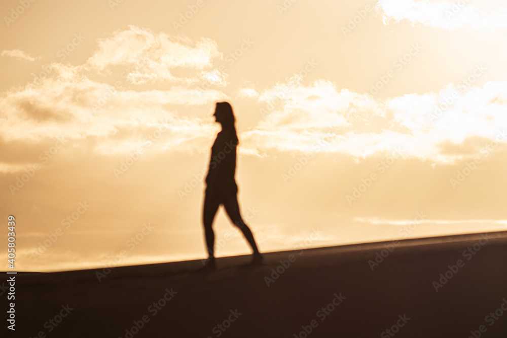 Woman shadow in the dunes during a sunset in Gran Canaria Woman shadow in the dunes during a sunset in Gran Canaria